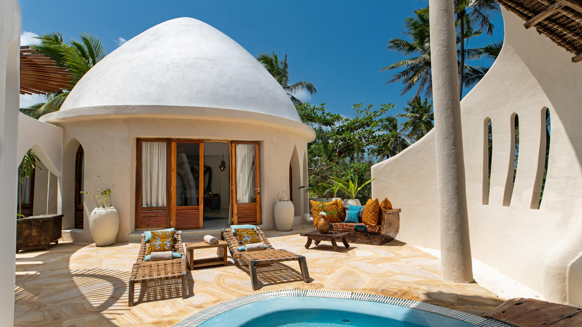 Terrasse einer weißgetünchten Luxusvilla mit Runddach.