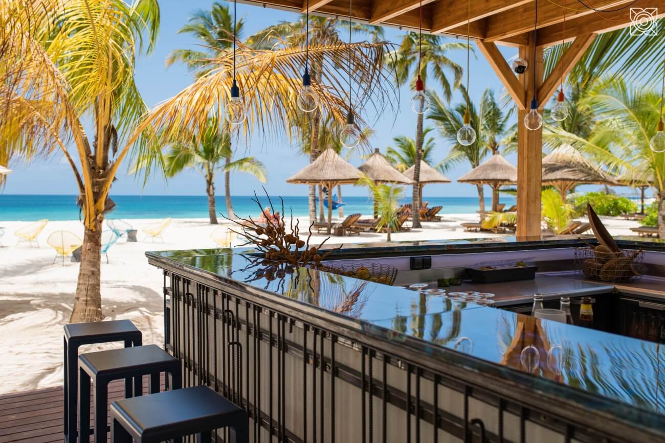 Blank polierte Beachbar mit Palmen, Strand und Meer.