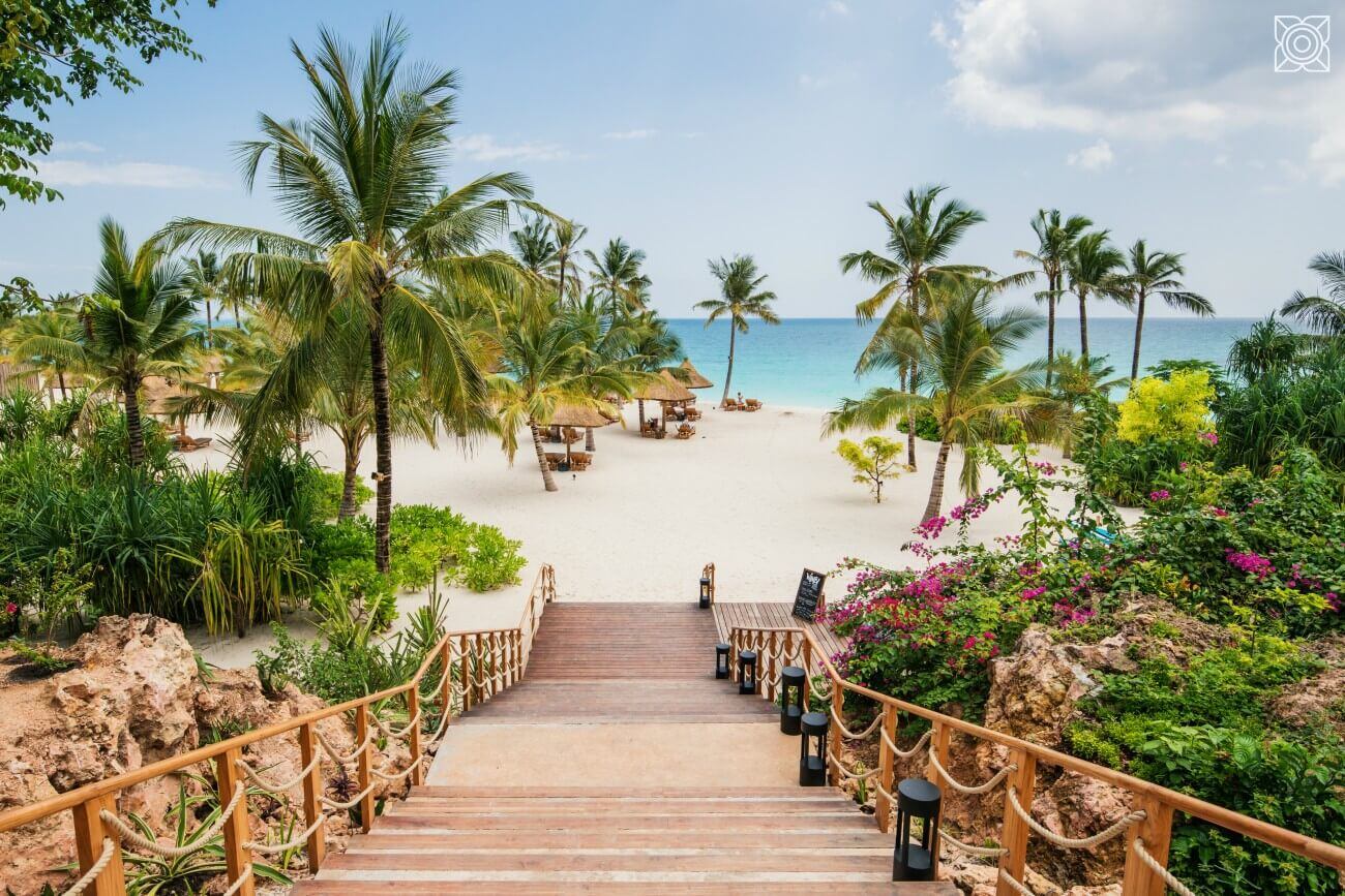 Eine Holztreppe führt hinunter zum Strand.