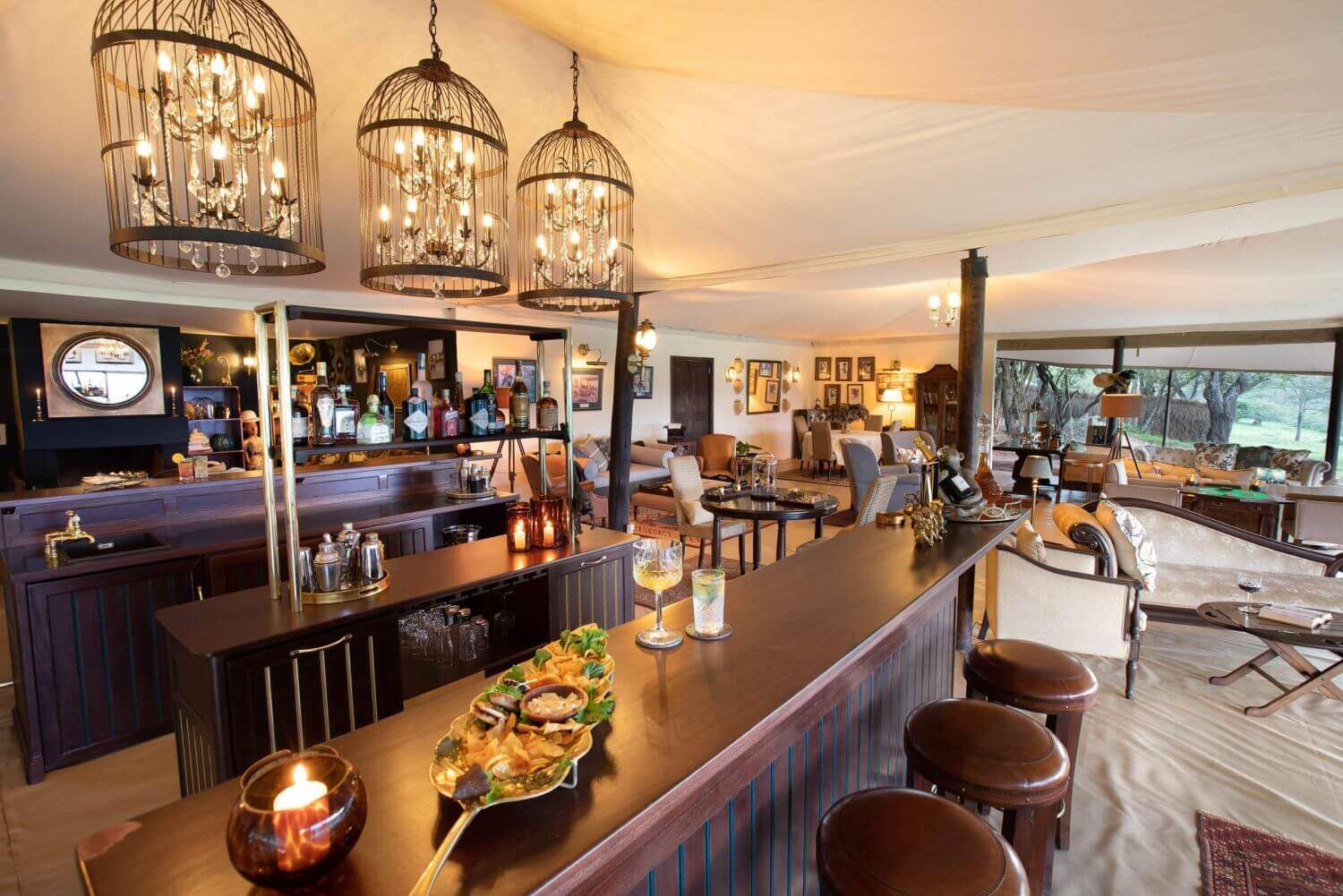 Elegante Bar mit Fingerfood, im Hintergrund stehen gemütliche Sessel und Sofas.