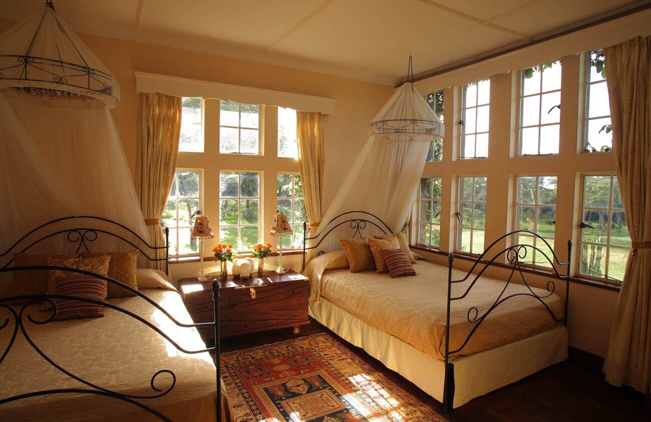 Schlafzimmer mit zwei Einzelbetten mit einem Mückenschutz.