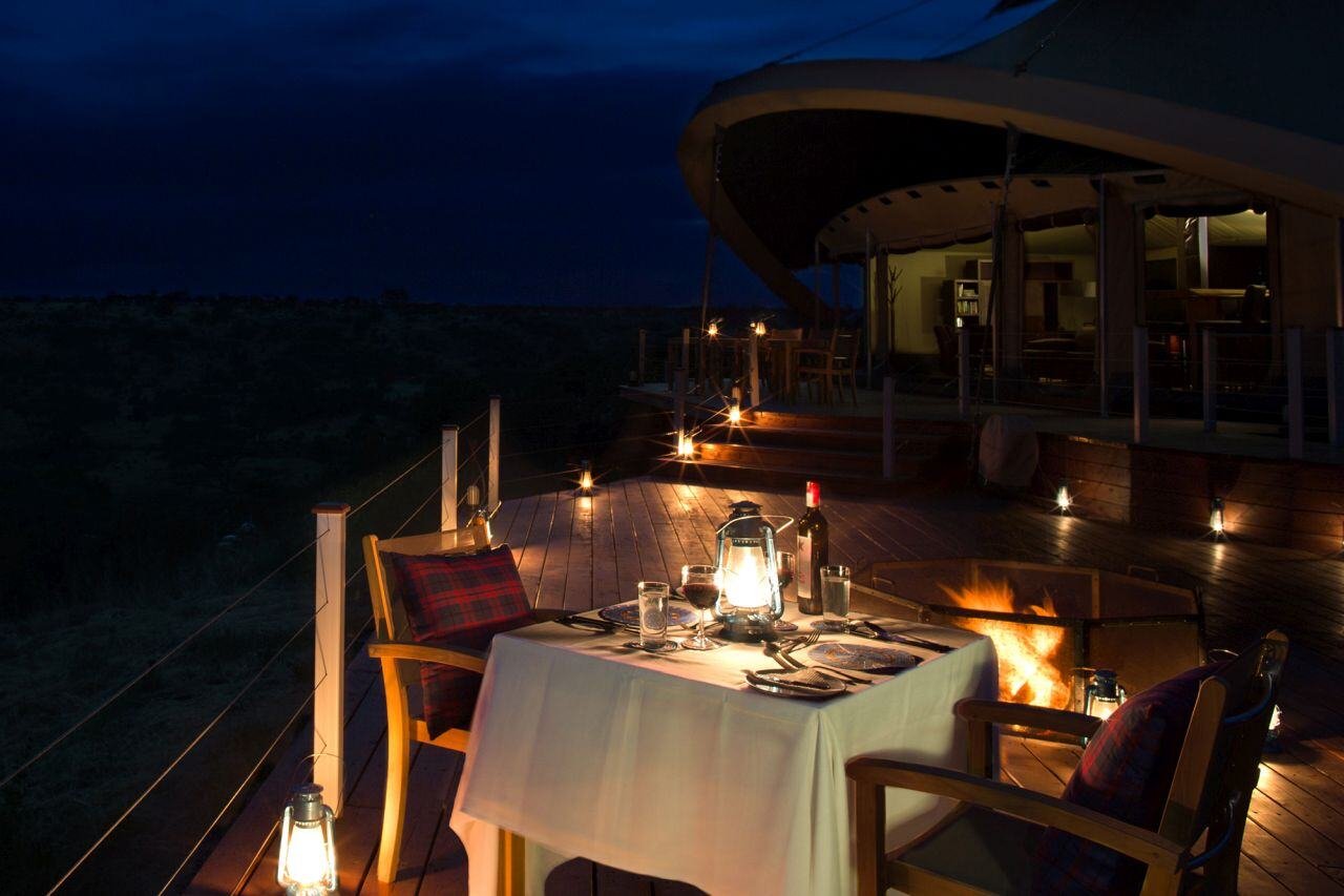 Abendstimmung im Restaurant unterm freien Himmel. Die Einrichtung ist sanft mit Kerzen beleuchtet.