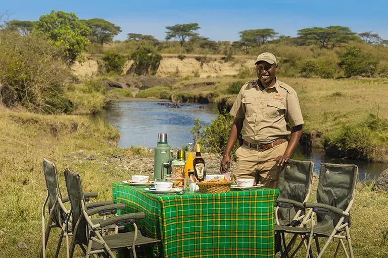Frühstück vor der Kulisse eines Flusses in der Masai Mara.