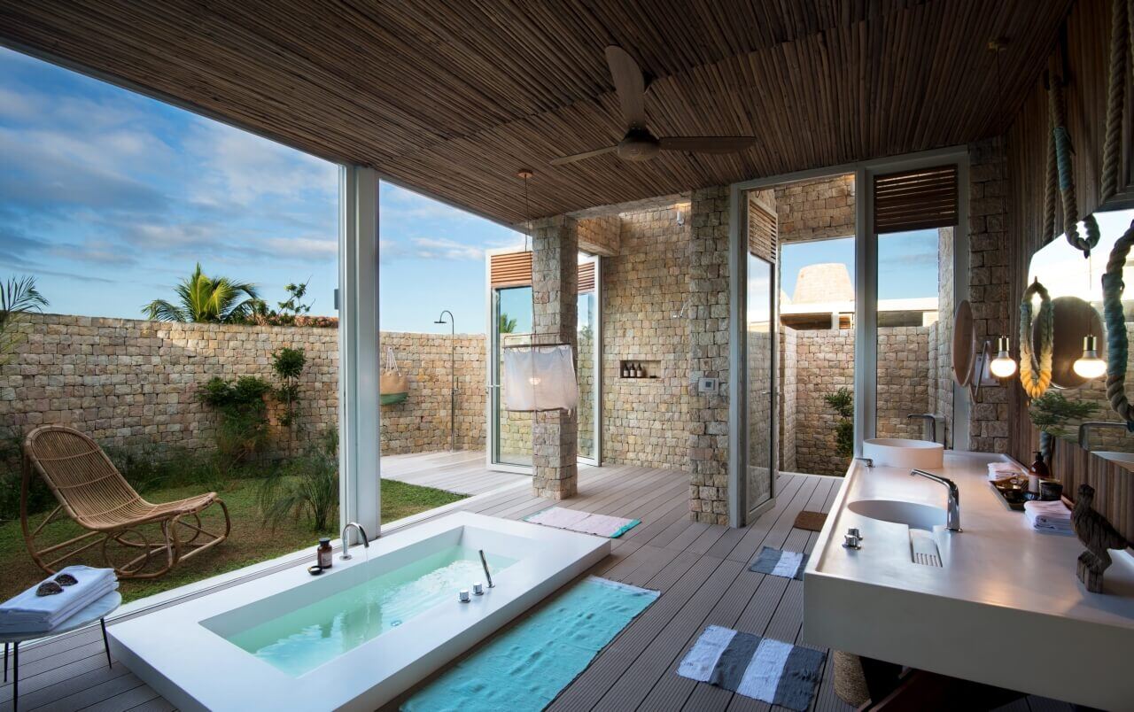 Luxuriöses Badezimmer einer Luxusvilla mit Badewanne zum Garten.