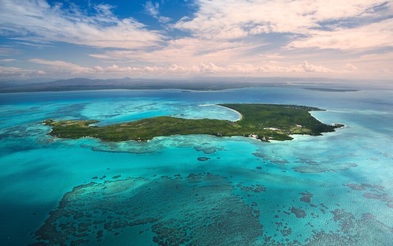 Resorts aus der Vogelperspektive: Grüne Insel umgeben von türkisem Wasser.