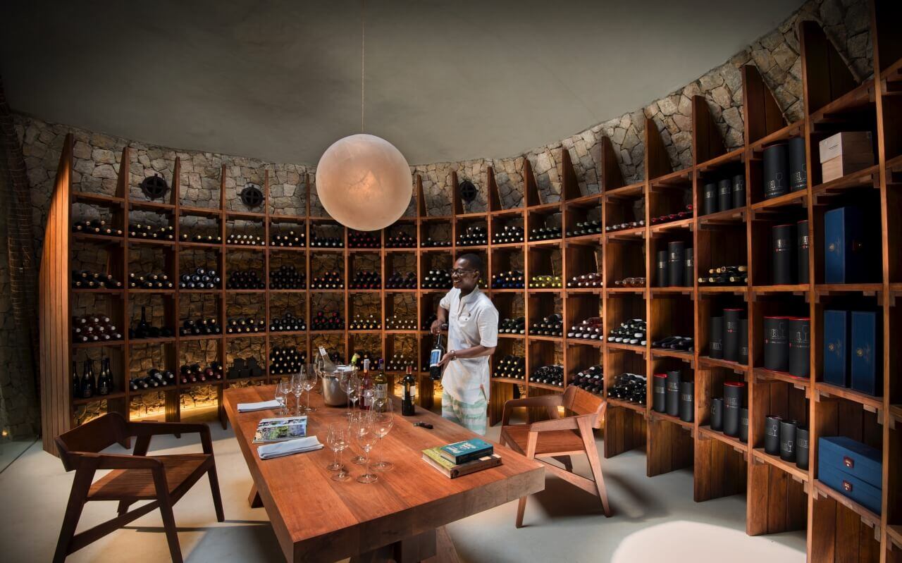 Ein Sommelier steht an einem Tisch in einem Weinkeller.