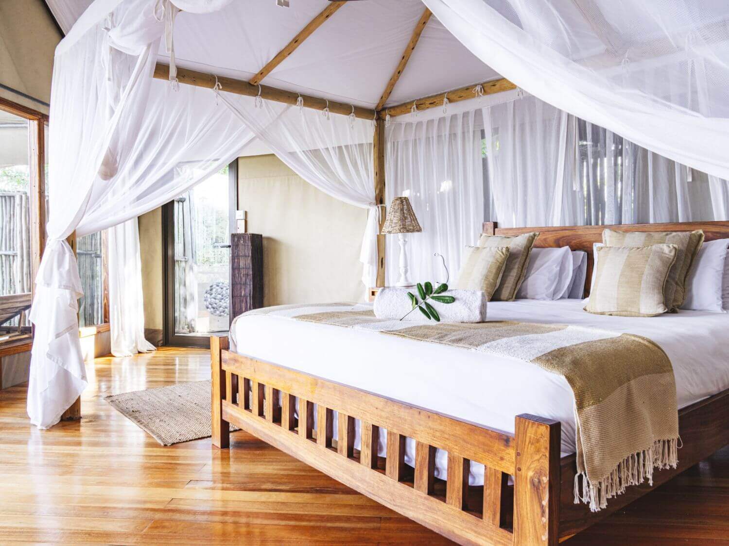 Kingsize-Bett umgeben von Tüchern, wirkt sehr elegant.