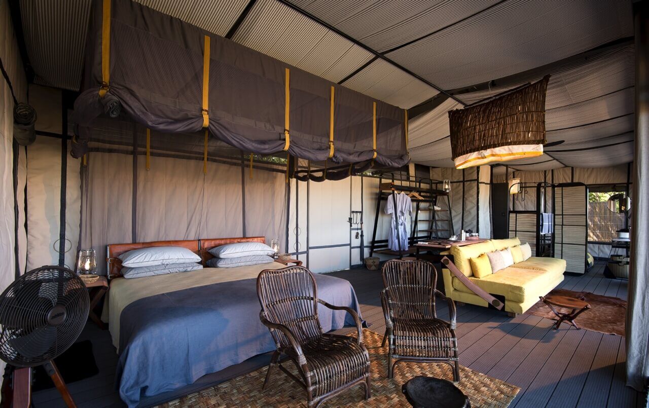 Geräumige Zeltsuite mit Kingsize-Bett, Sofa und Stühlen.