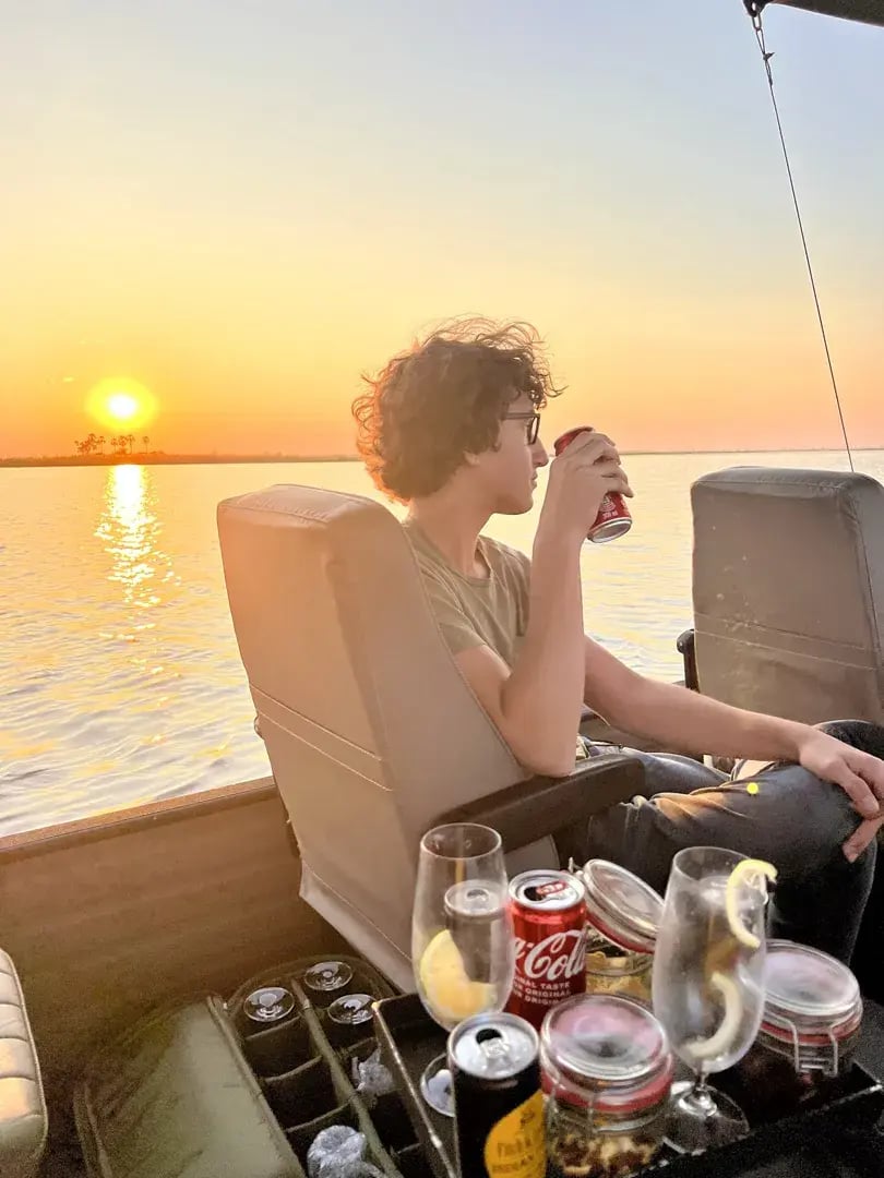 Sundowner mit leckeren Snacks, ein Jungen nimmt gerade ein Getränk zu sich.