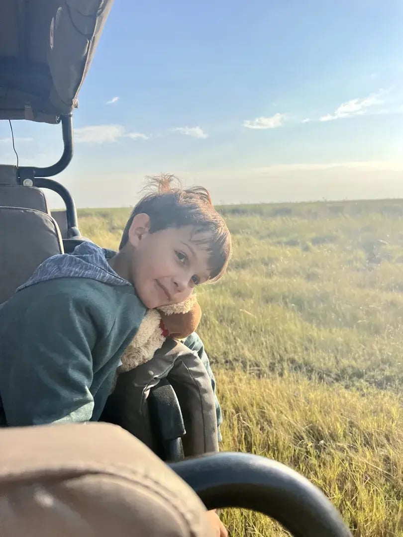 Kleiner Junge im Safarifahrzeug, im Hintergrund die weite Wildnis.