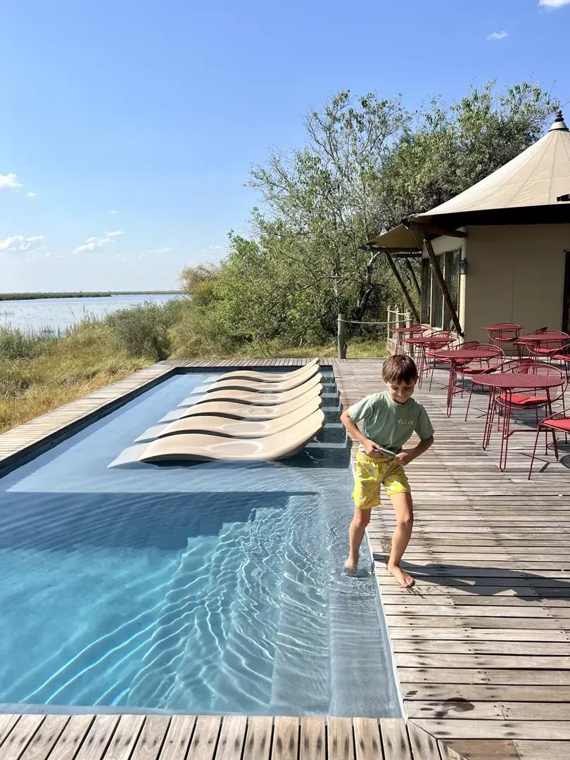 Pool in einer Lodge, ein kleiner Junge hält seinen Fuß ins Wasser.