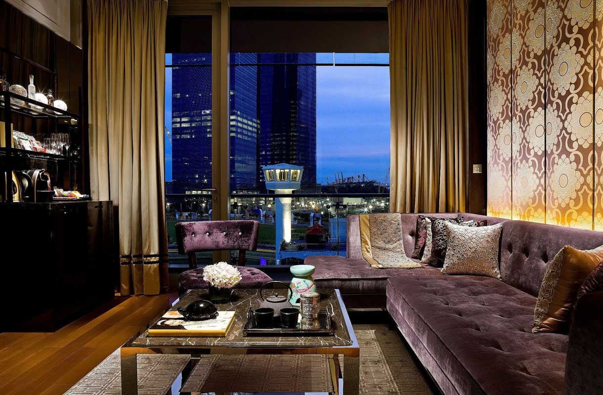 Raumansicht des Anderson-Suite Wohnzimmers mit großem Fenster im Fullerton Bay Hotel