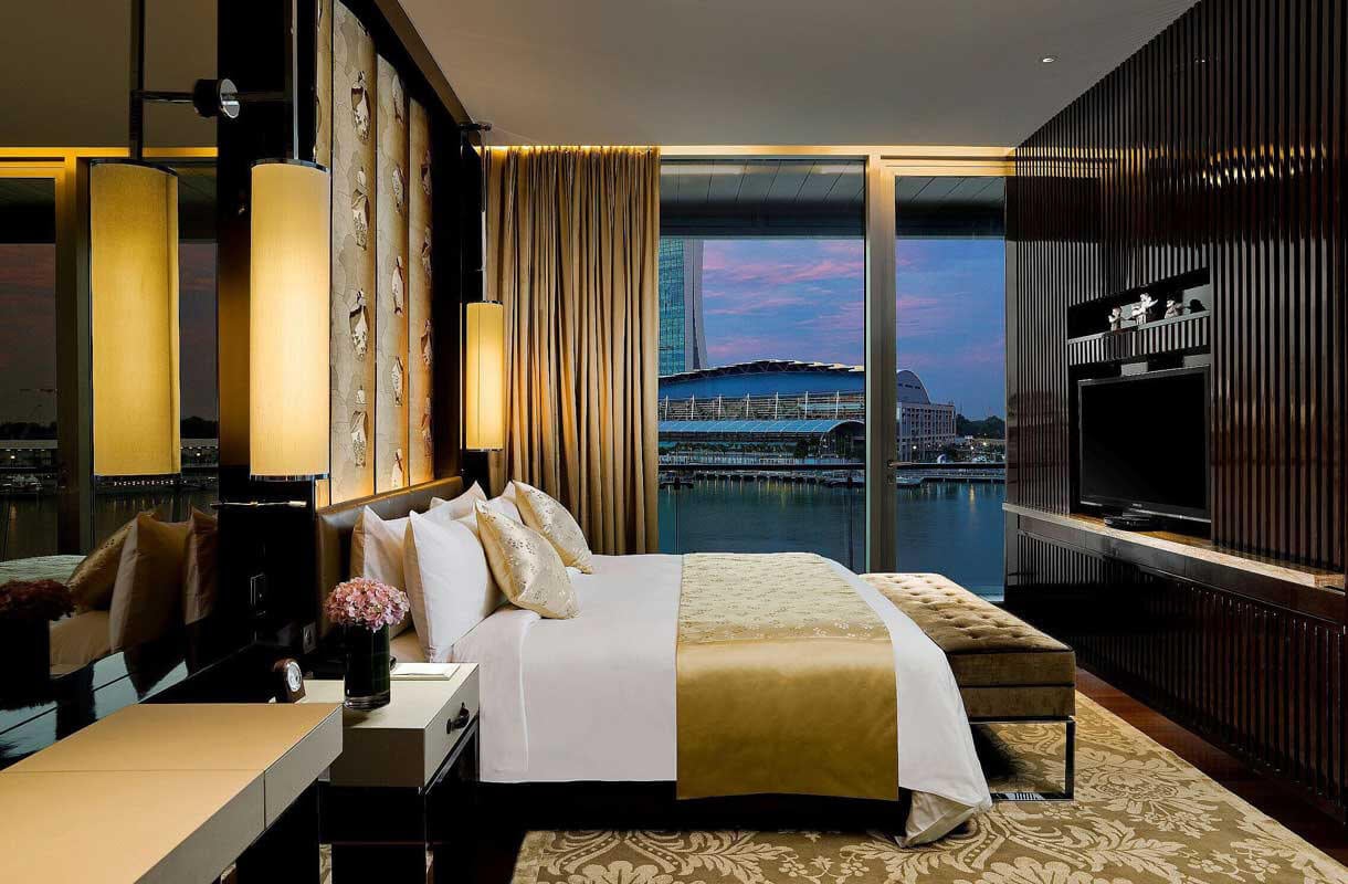 Raumansicht der Cavenagh-Suite Schlafzimmers mit Hafenblick im Fullerton Bay Hotel