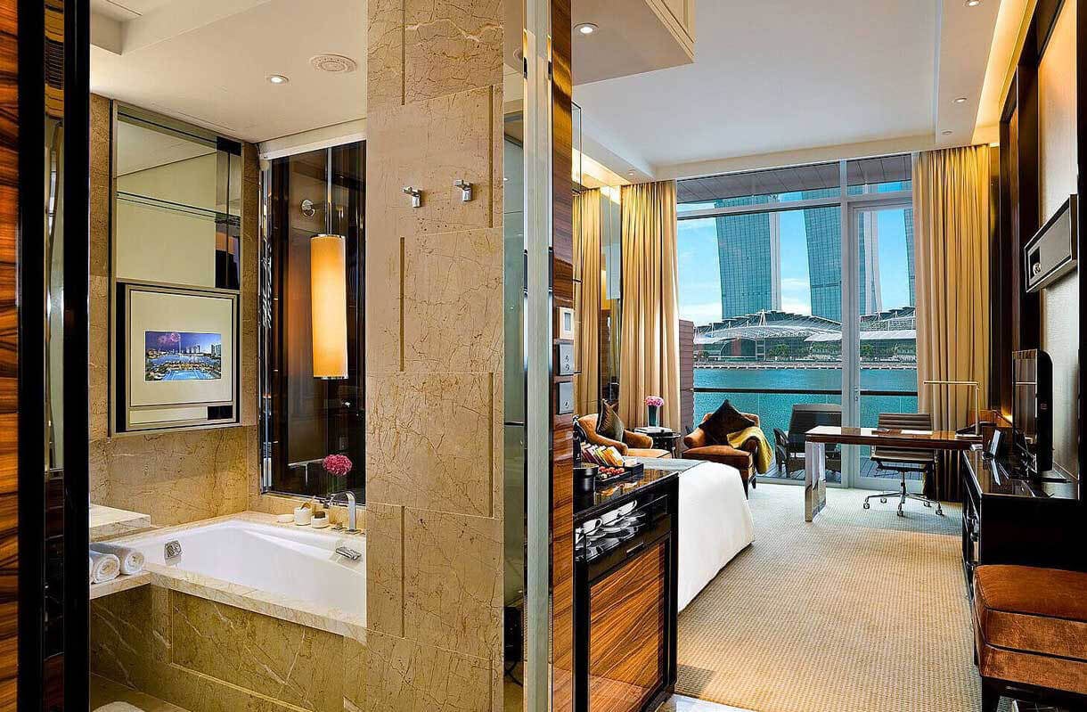 Raumansicht des Premier Bay Raumes im Fullerton Bay Hotels mit Badewanne und Blick auf den Hafen