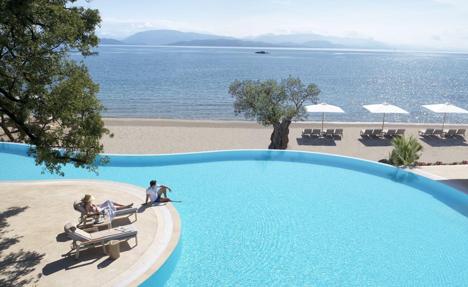 Pool mit Liegen und Blick aufs Meer.
