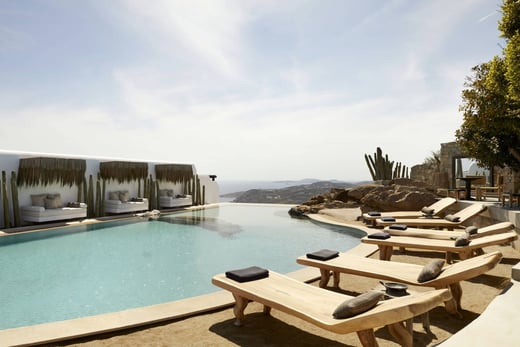 Pool mit Sonnenliegen im Myconian Ambassador Relais & Chateau Hotel