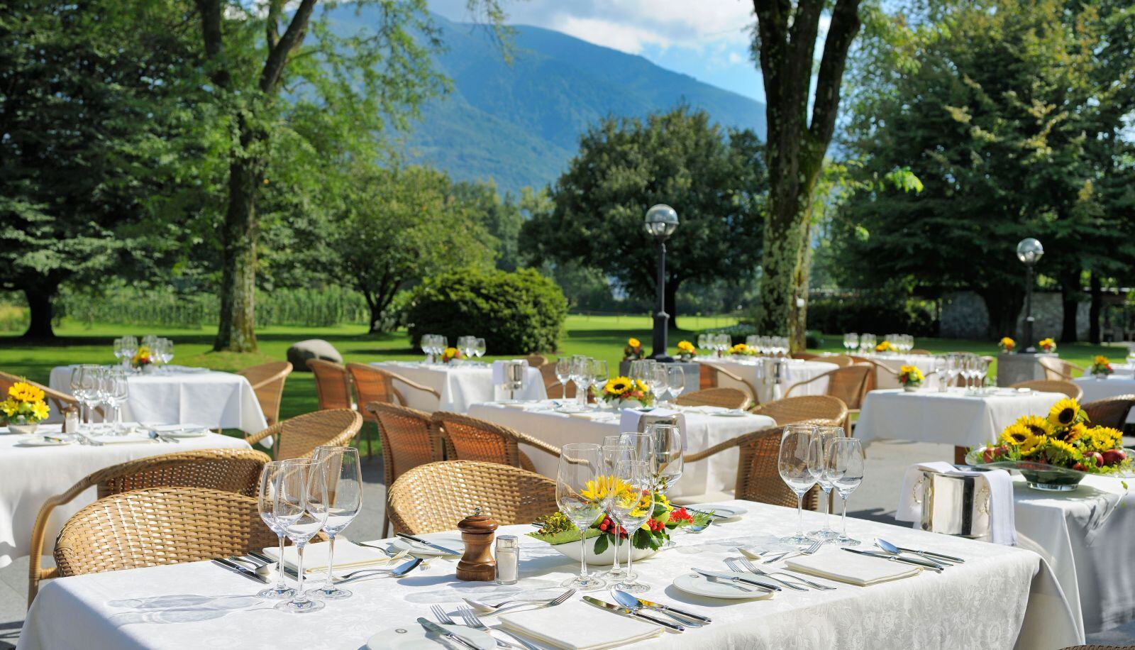 Restaurant im Garten mit schicken, eingedeckten Tischen.