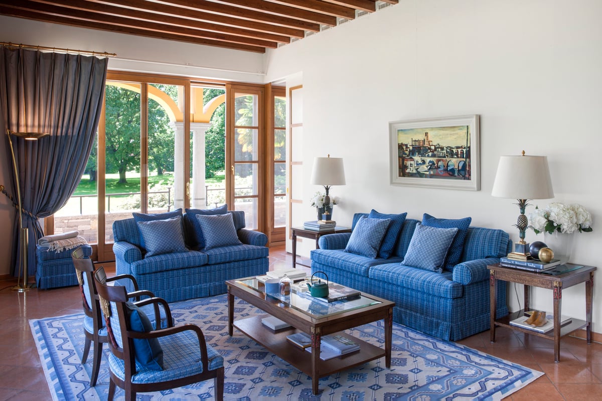 Großes Wohnzimmer mit blauen Sofas und Stühlen.
