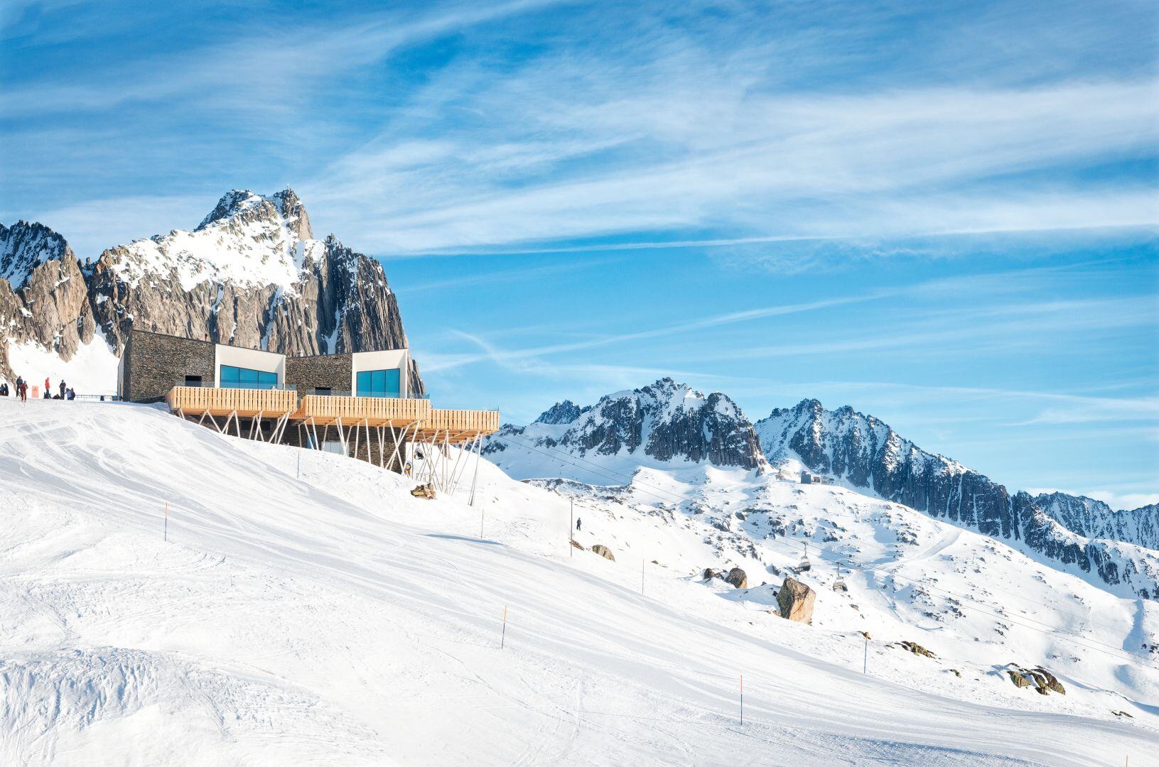 Verschneite Alpen mit einem Hotel.