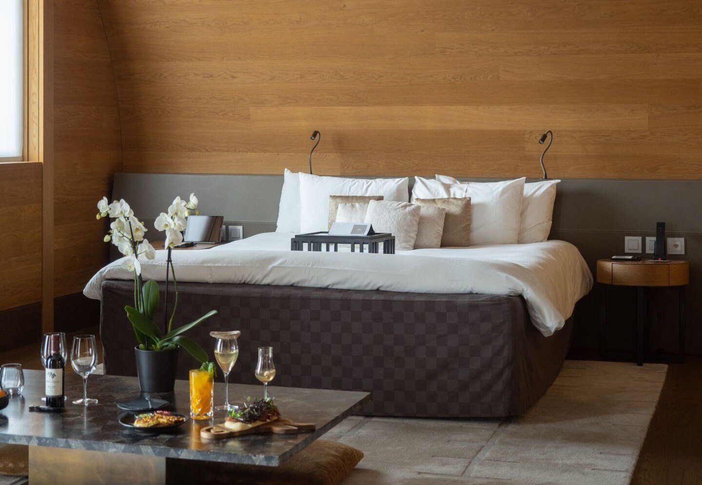 Hotelzimmer mit Doppelbett, auf einem Tisch stehen Getränke.