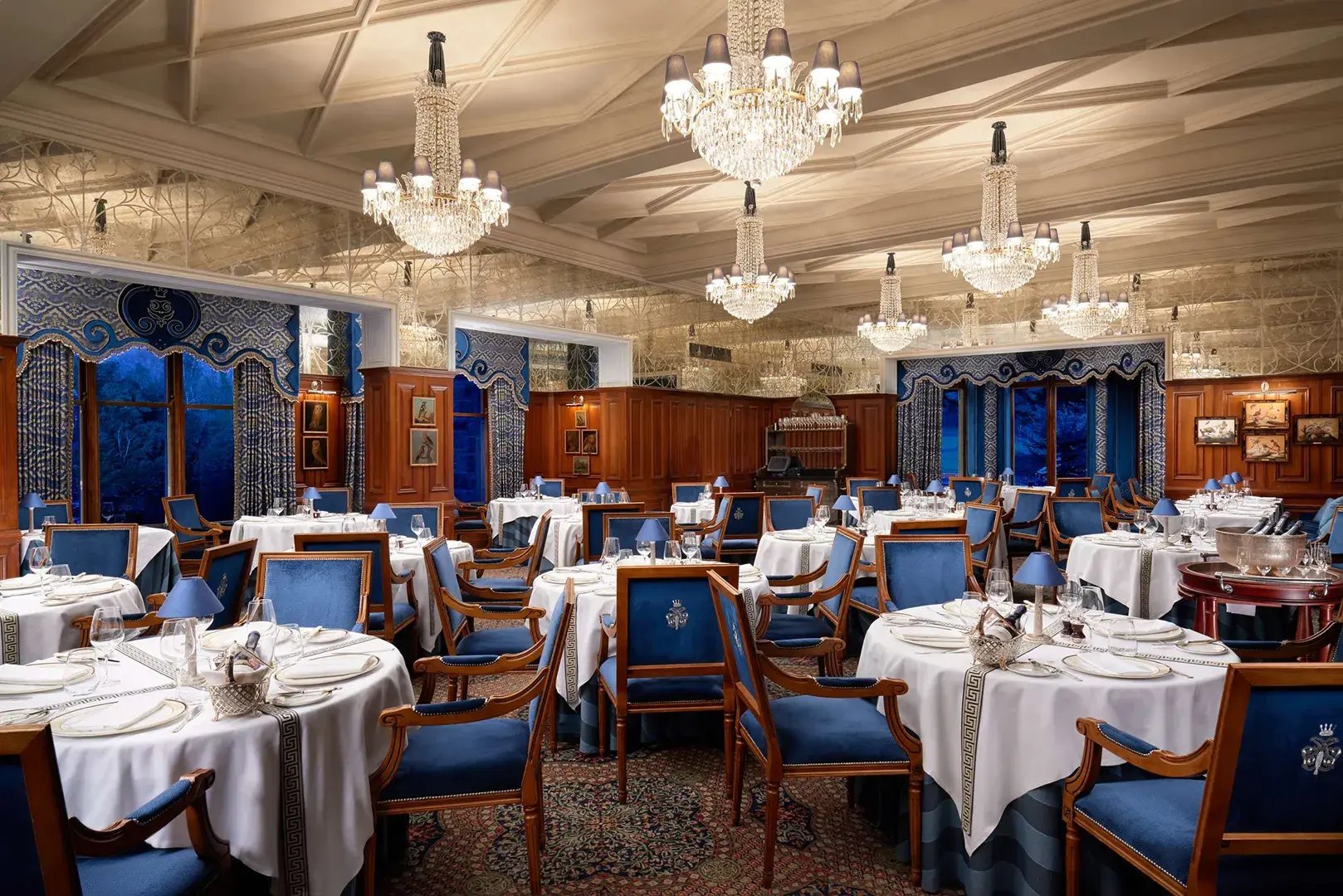 Edles Restaurant mit Wandvertäfelungen und Kronleuchtern.
