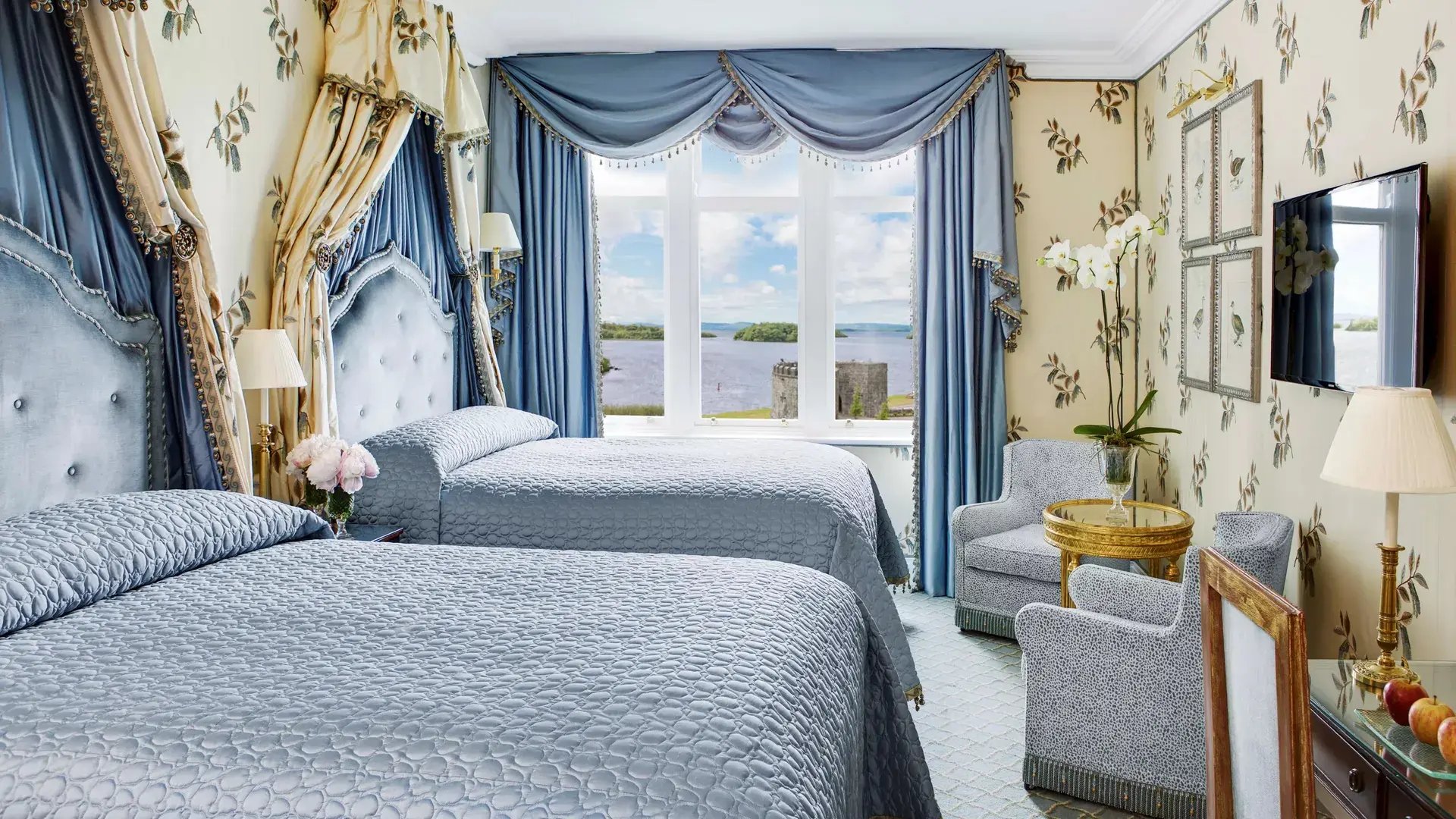 In Blau gehaltenes Schlafzimmer mit Blick auf einen See.