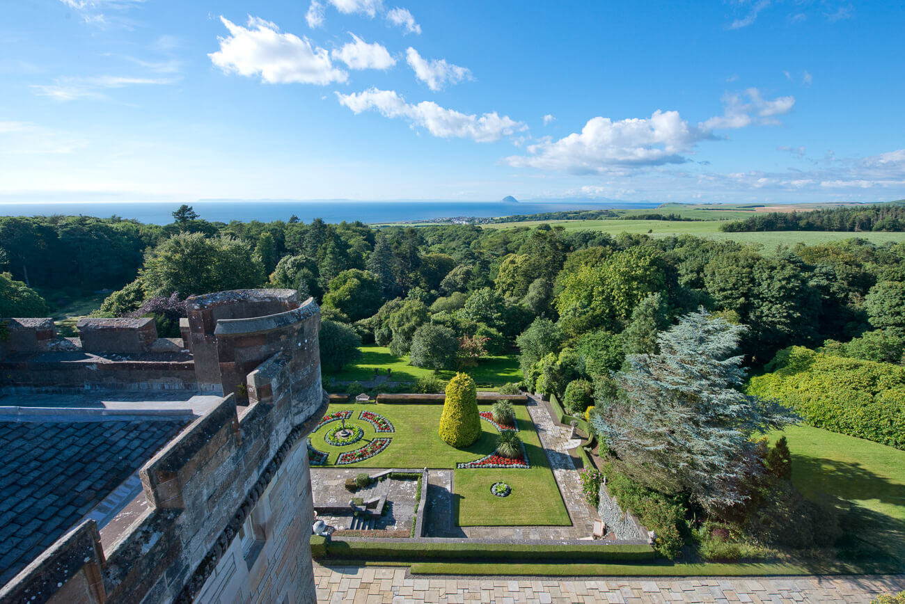 Blick vom Burgfried eines Schloss auf Anwesen und Landschaft.