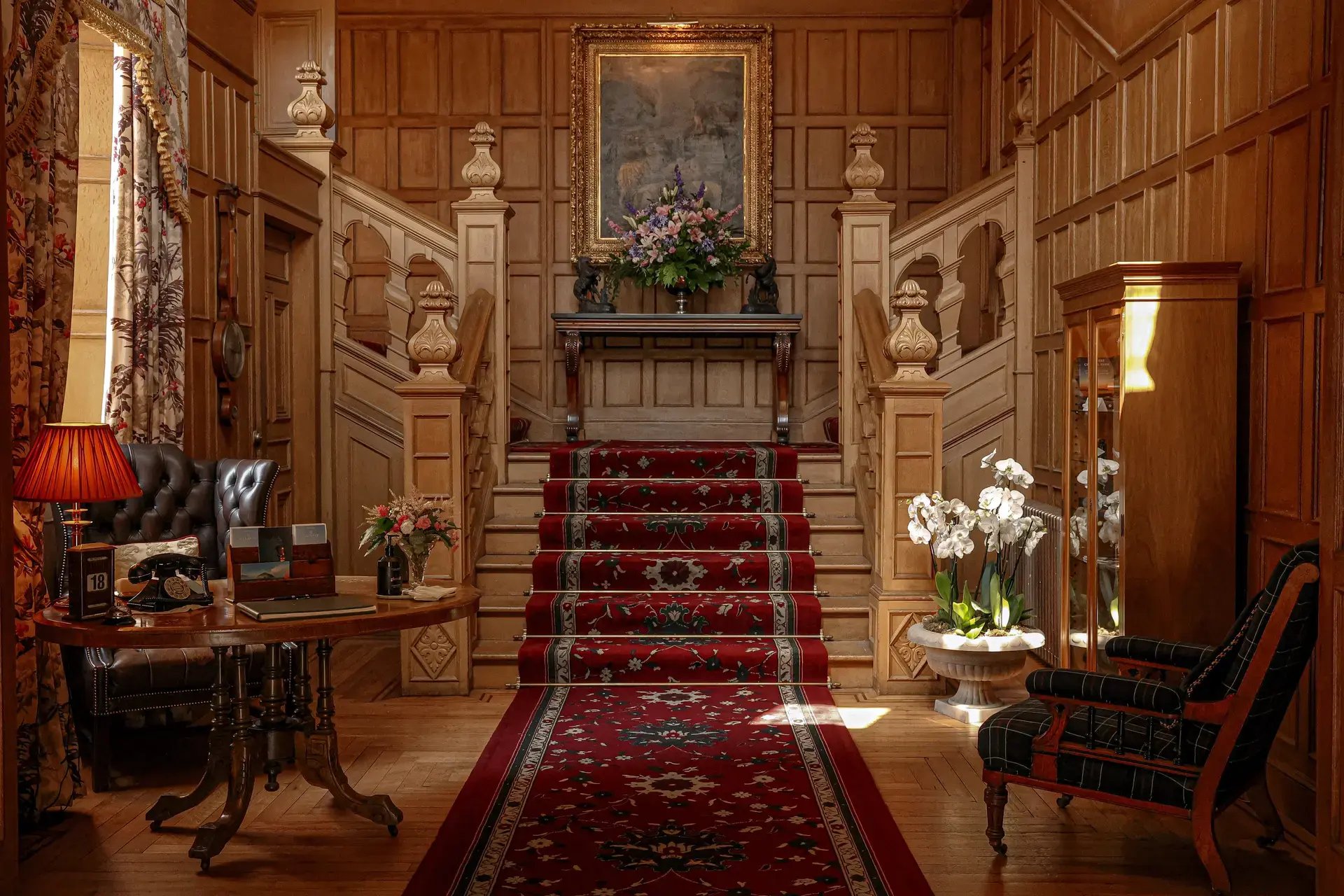Herrschaftlicher Treppenaufgang mit rotem Teppich in einem Schloss.