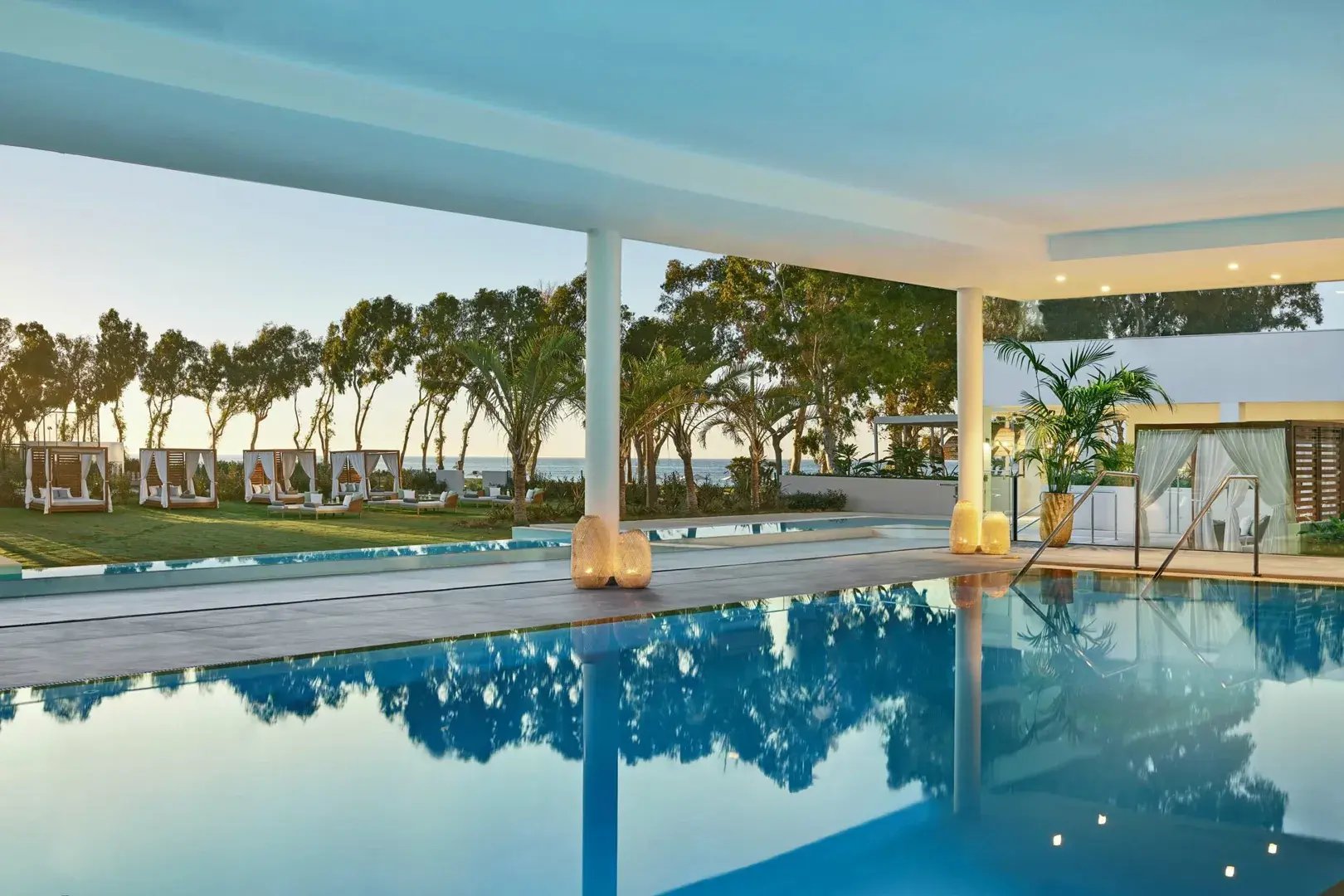 Überdachter Pool im Garten einer Hotelanlage.