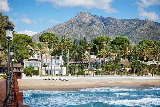 Hotelresort am Strand, im Hintergrund Berge.