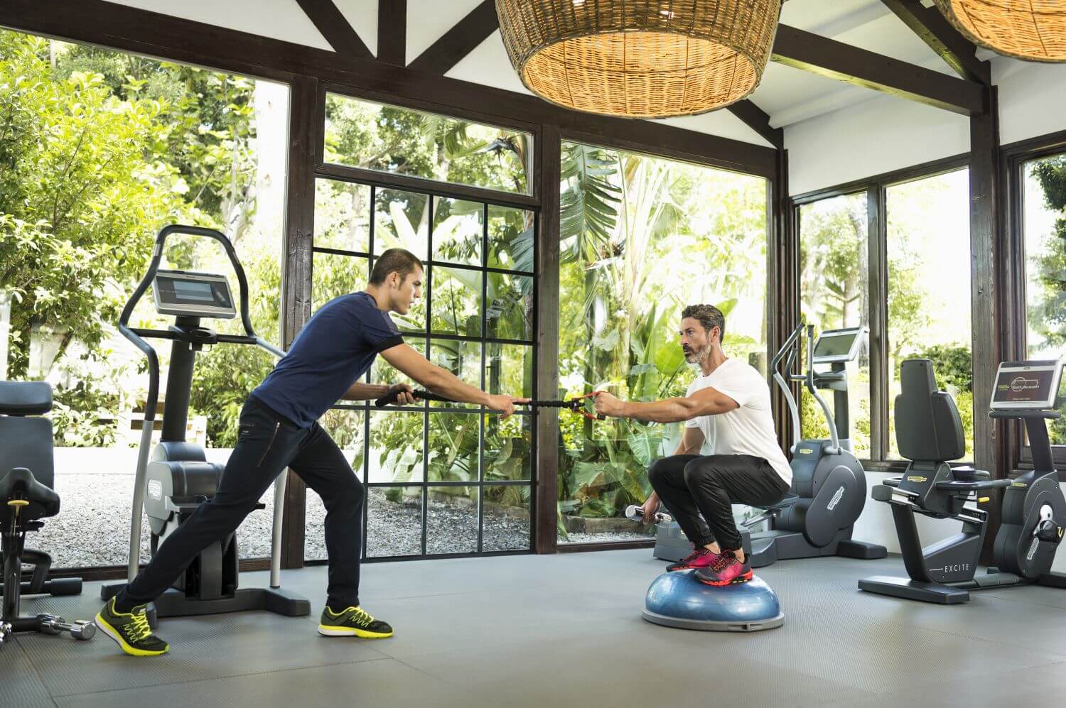 Zwei Männer machen im Gym gemeinsam Sport.
