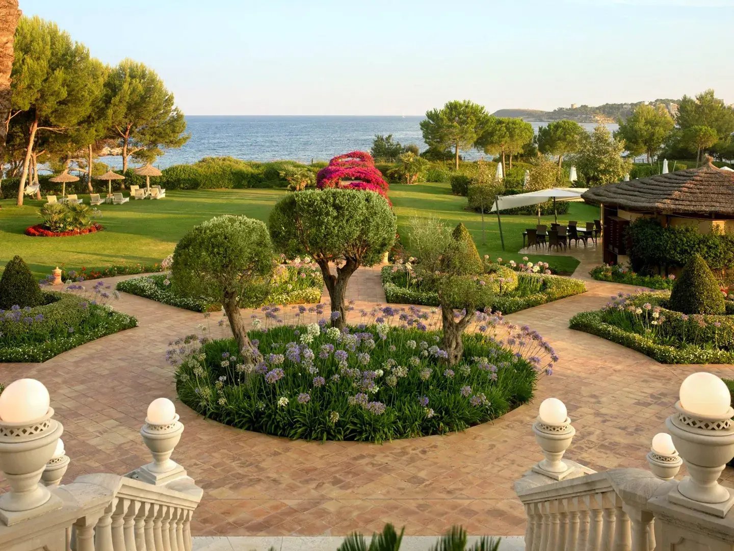 Edle Gartenanlage am Meer mit Beeten, Bäumen und vielen Sitzgelegeheiten.