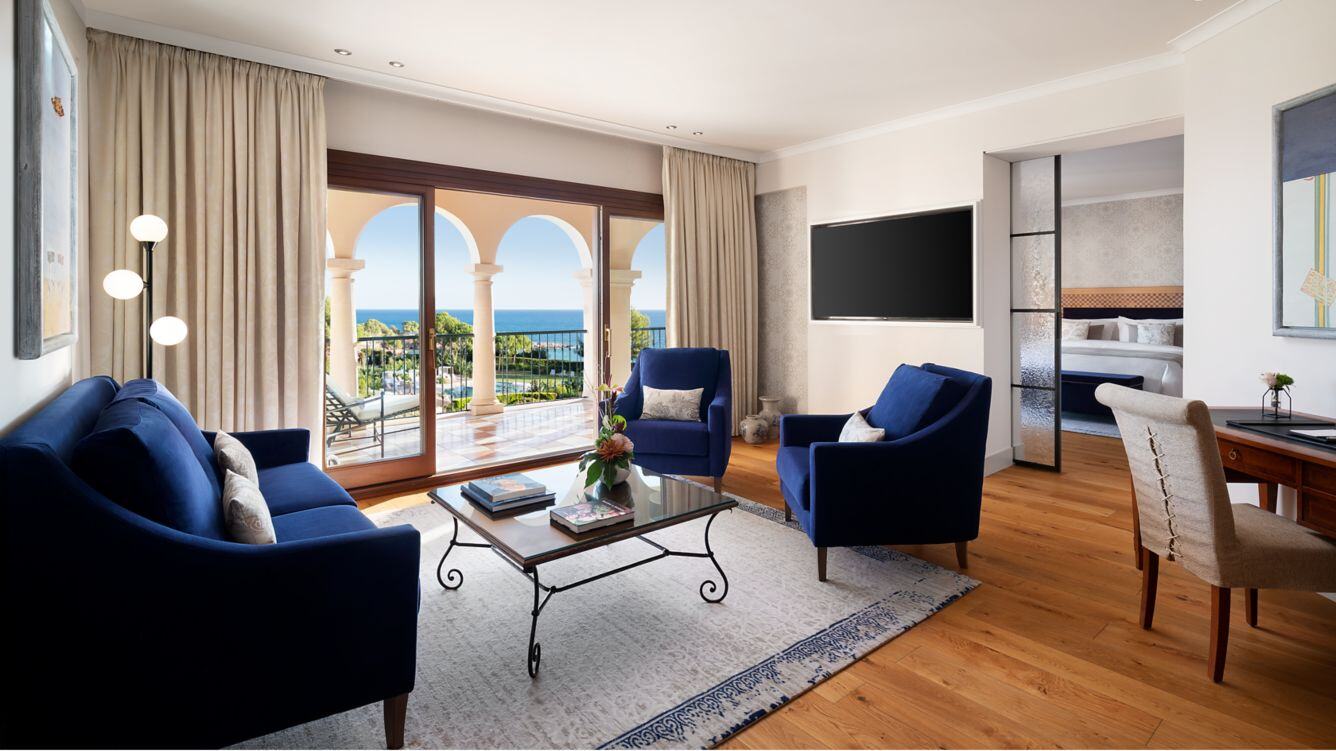 Großer Wohnbereich einer Suite mit blauen Sesseln.