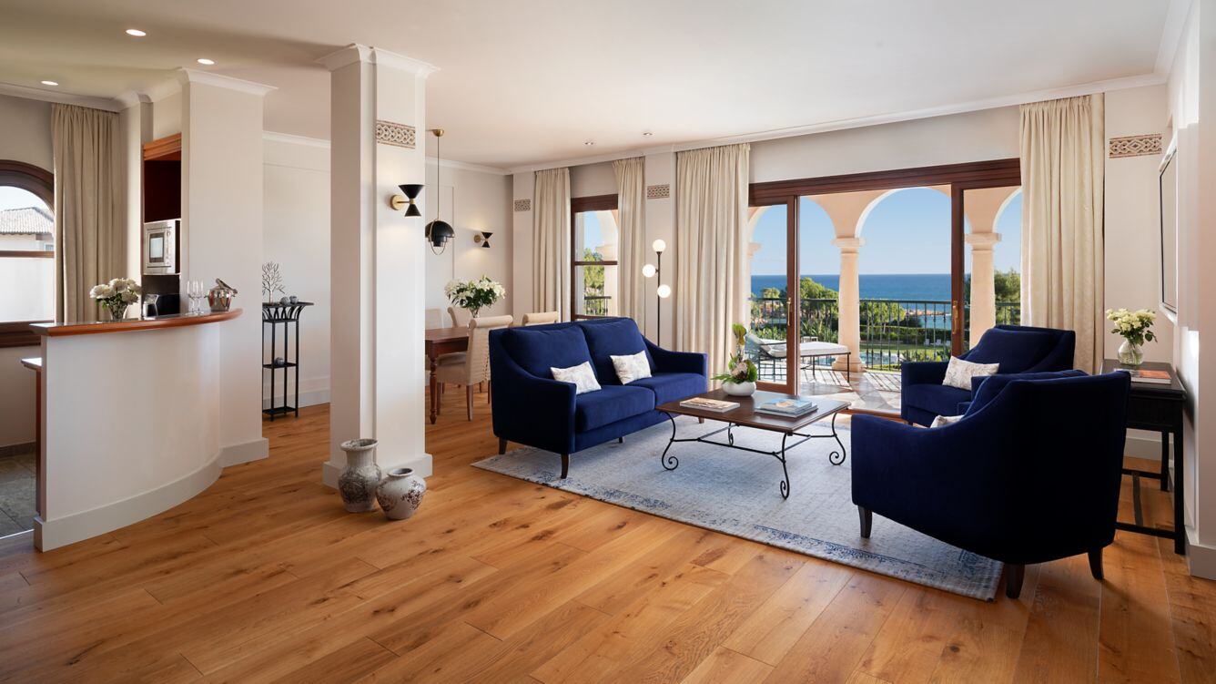 Großer Wohnbereich mit Theke und blauen Sesseln.