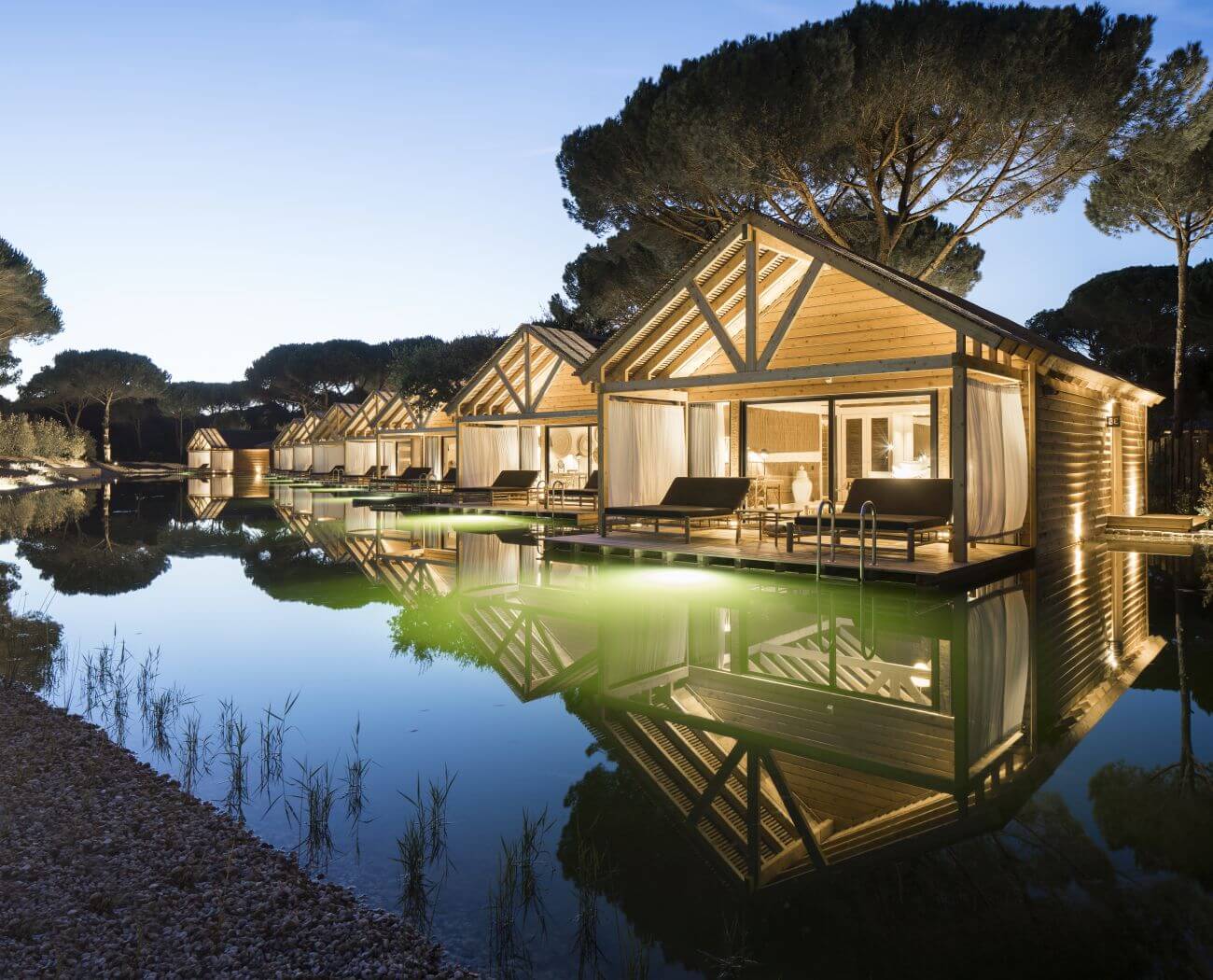 Cottages am See bei abendlicher Beleuchtung.