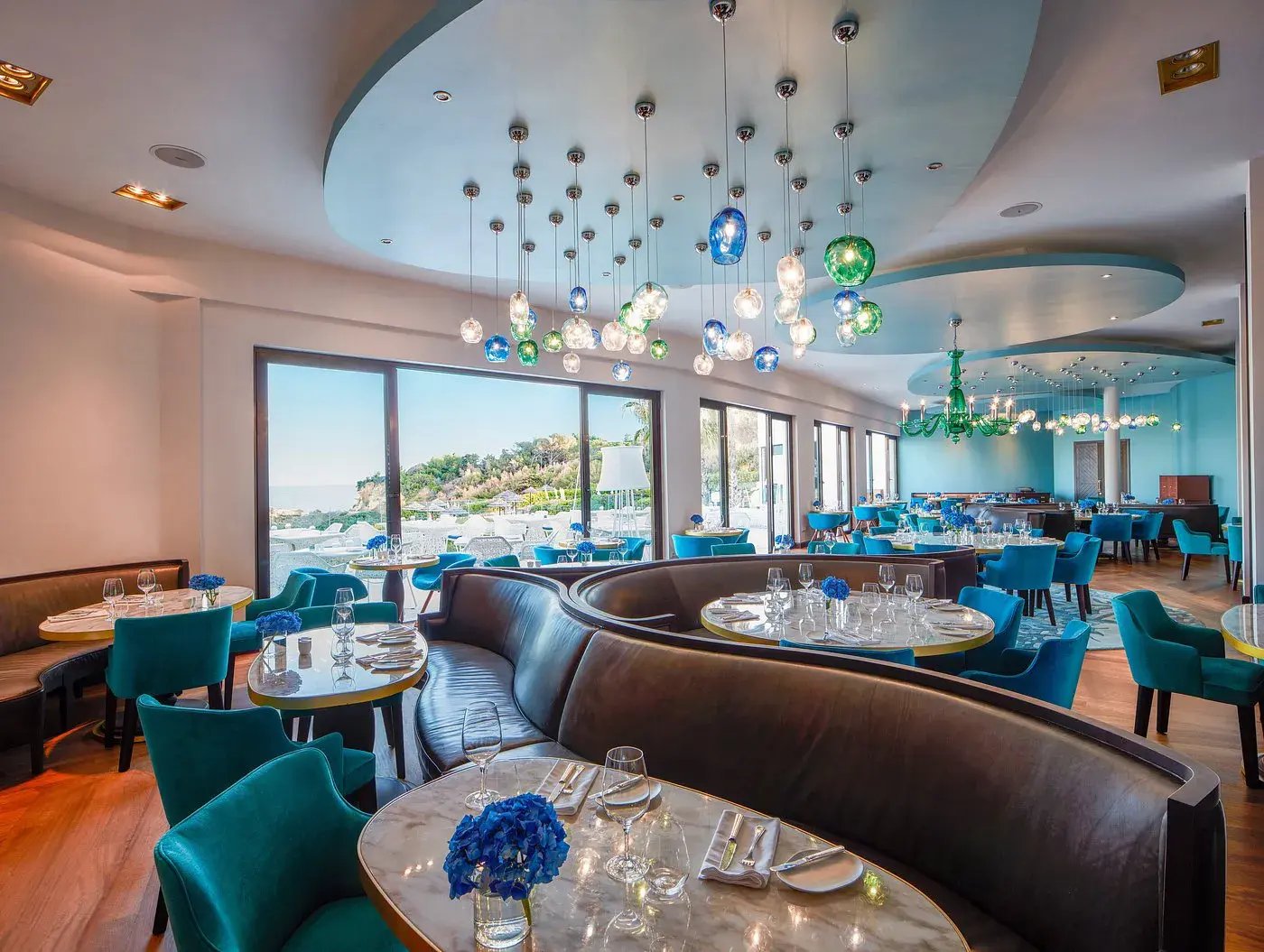 Modernes Restaurant mit blauen Stühlen und braunen Ledersofas.