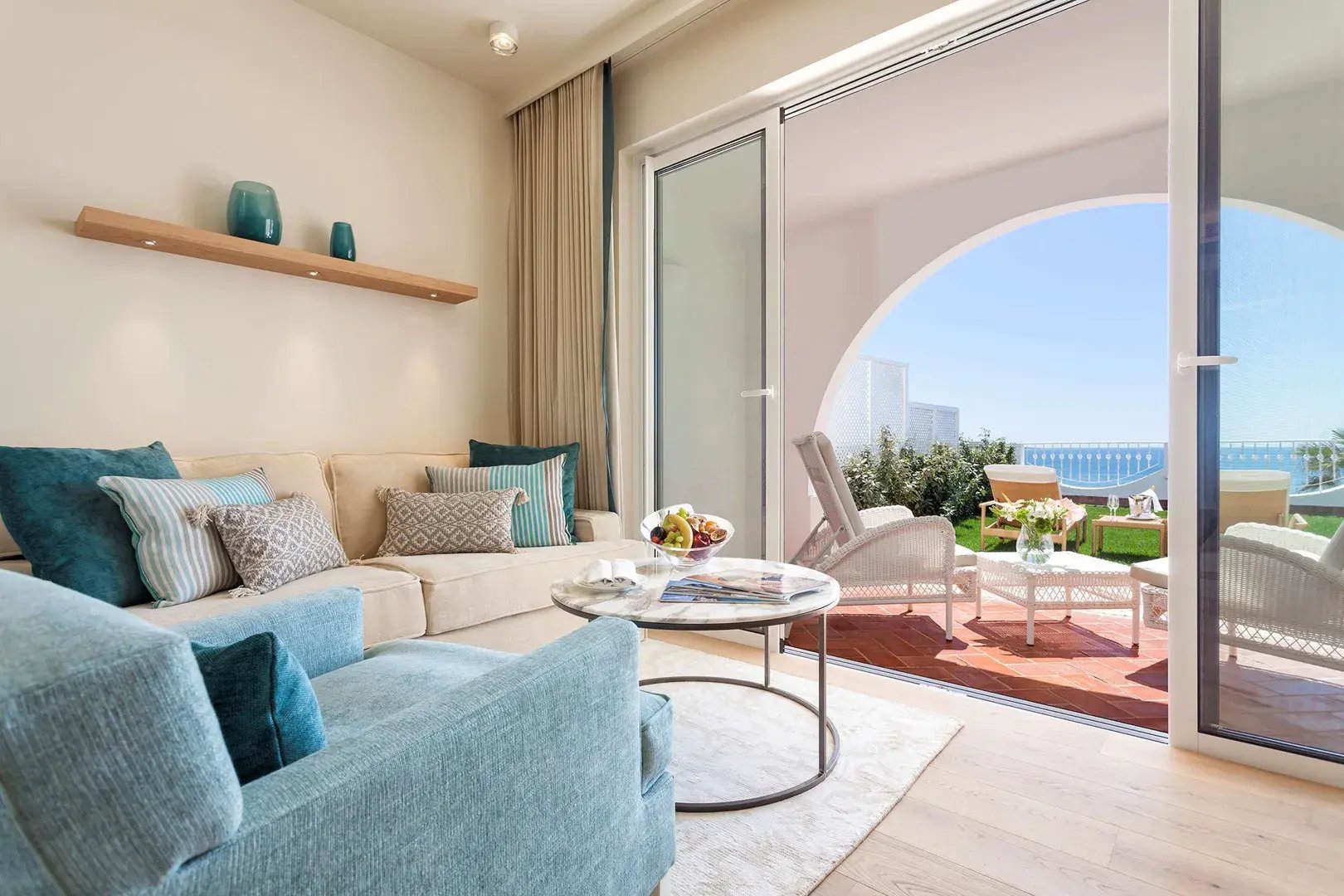 Gemütlicher, freundlicher Wohnbereich mit Balkon in einer Suite.