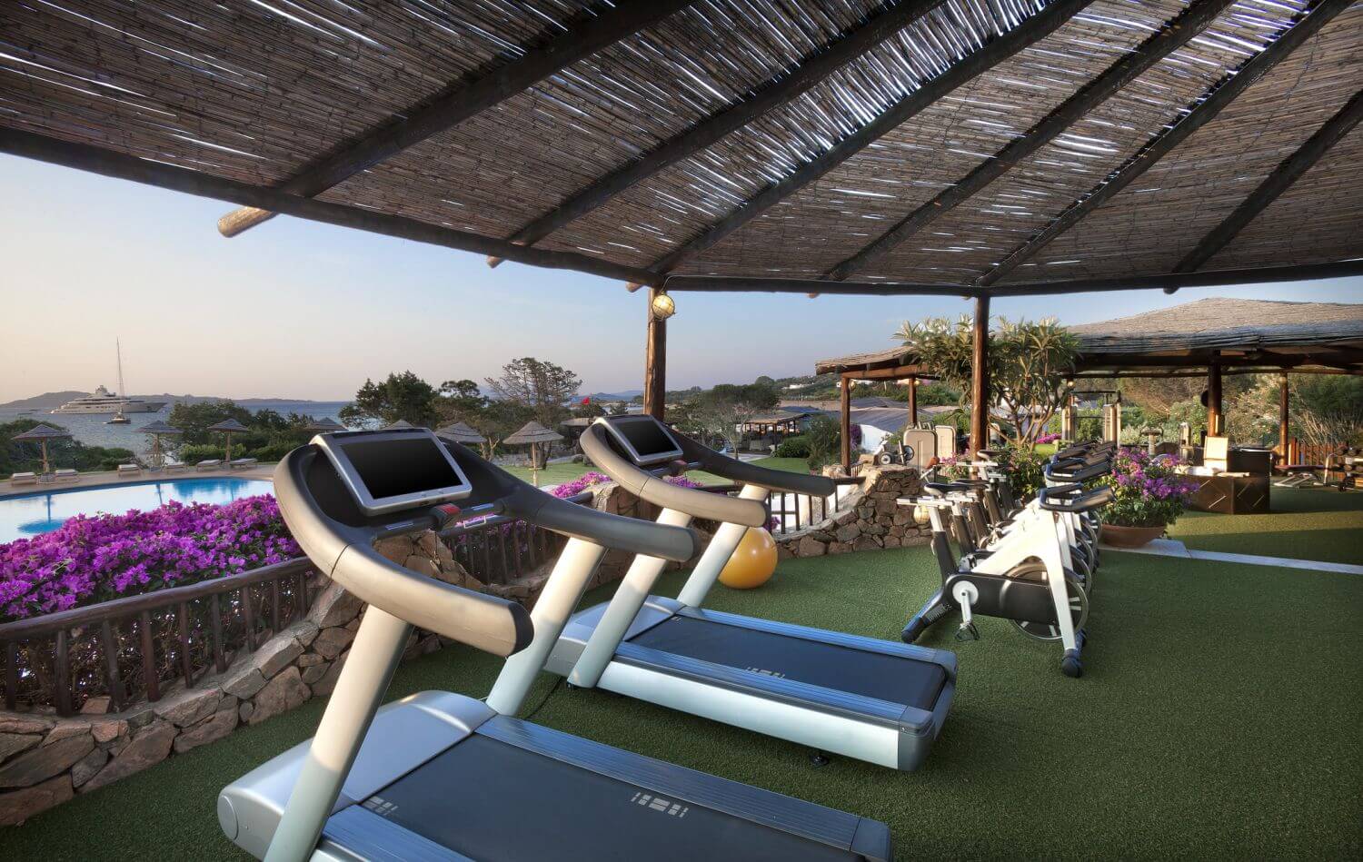 Überdachter Fitnessbereich auf einer Terrasse.