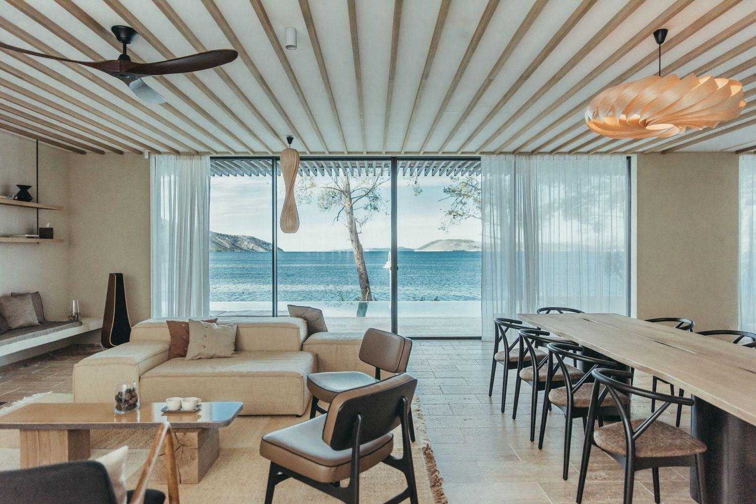 Moderner Wohnbereich Esstisch und Sofas und Blick auf Meer.
