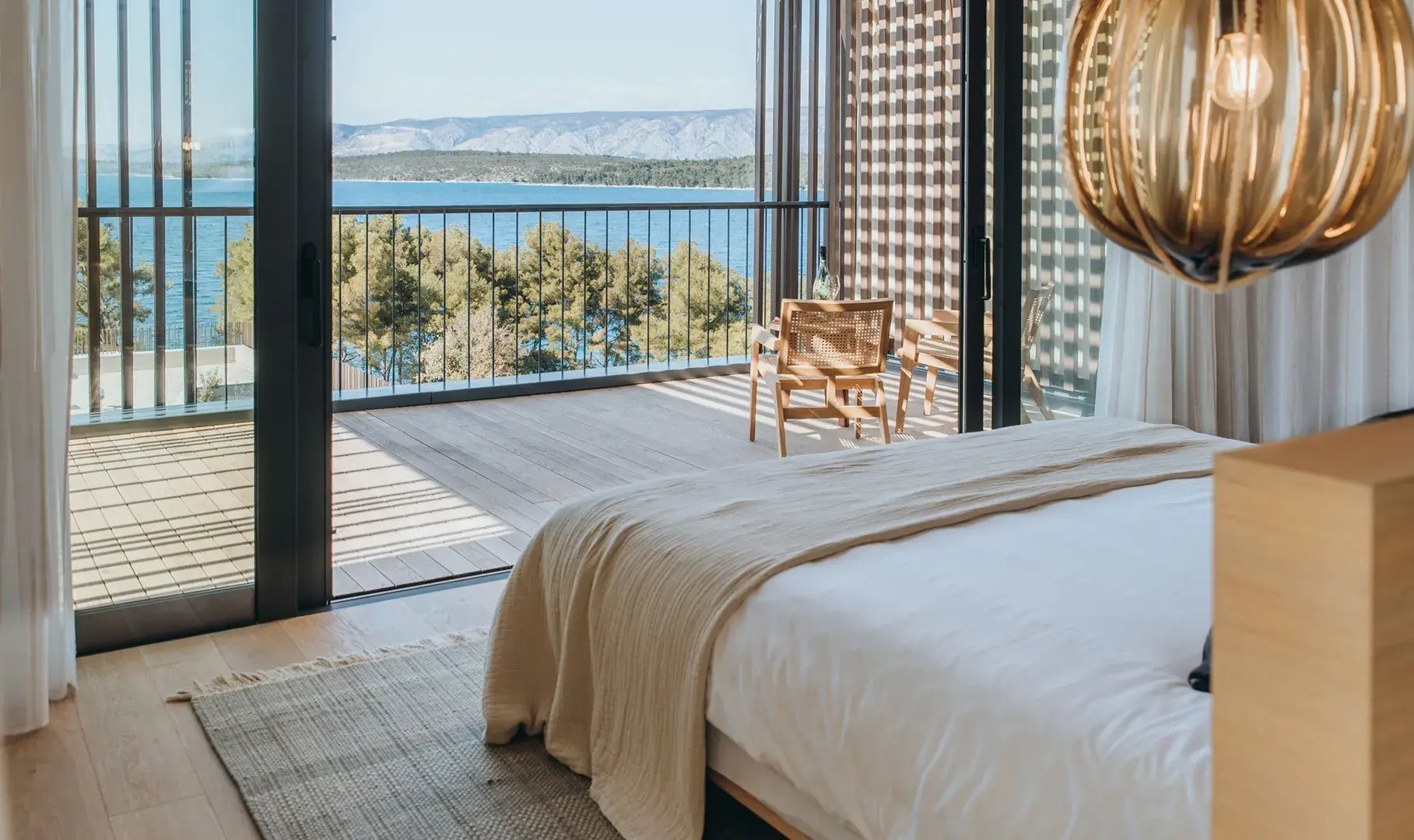Hotelzimmer mit Kingsize-Bett, von dem aus man direkt auf das Meer blickt.