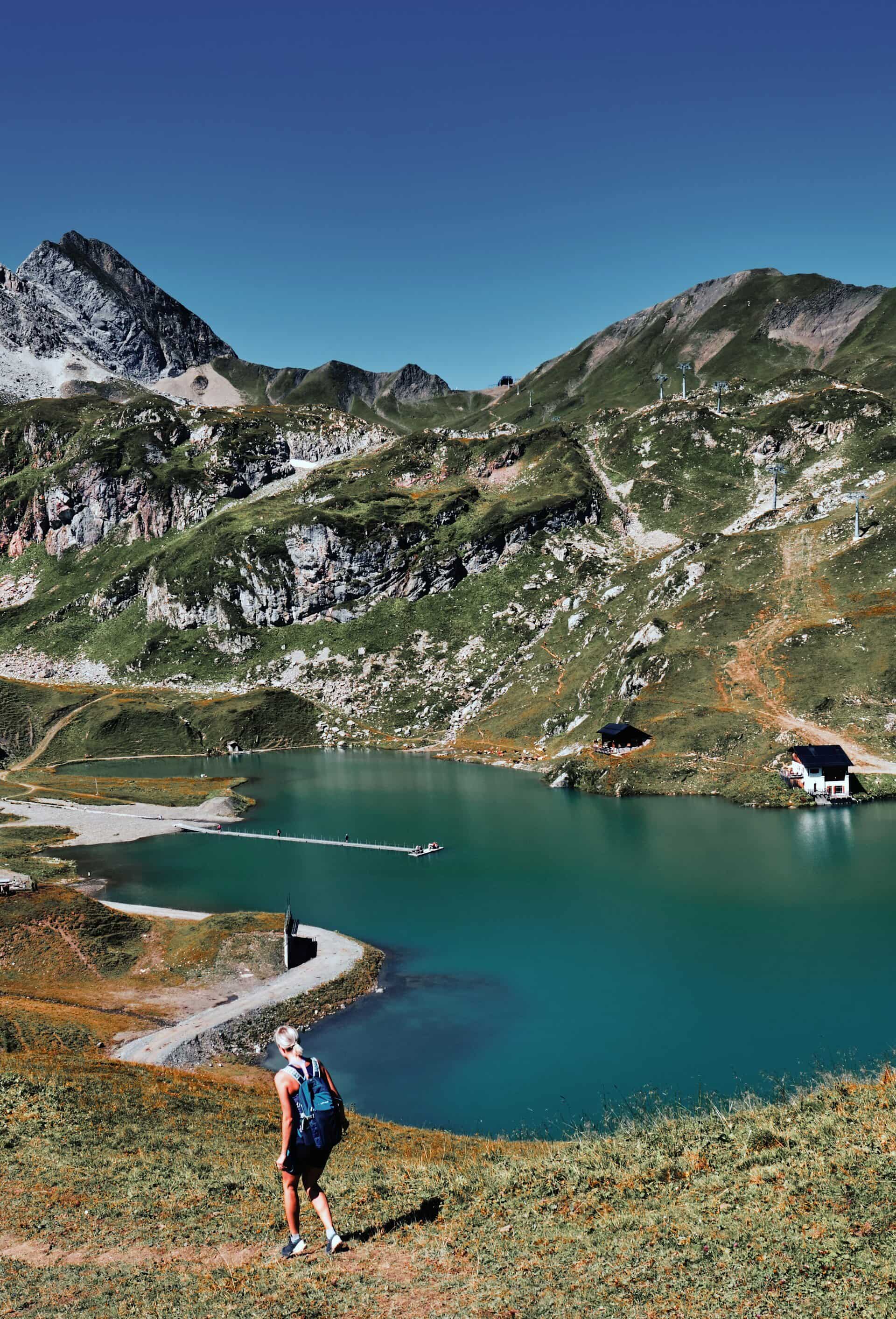 Aurelio-Lech-Familienluxusreisen Frau wandert an blauem Bergsee