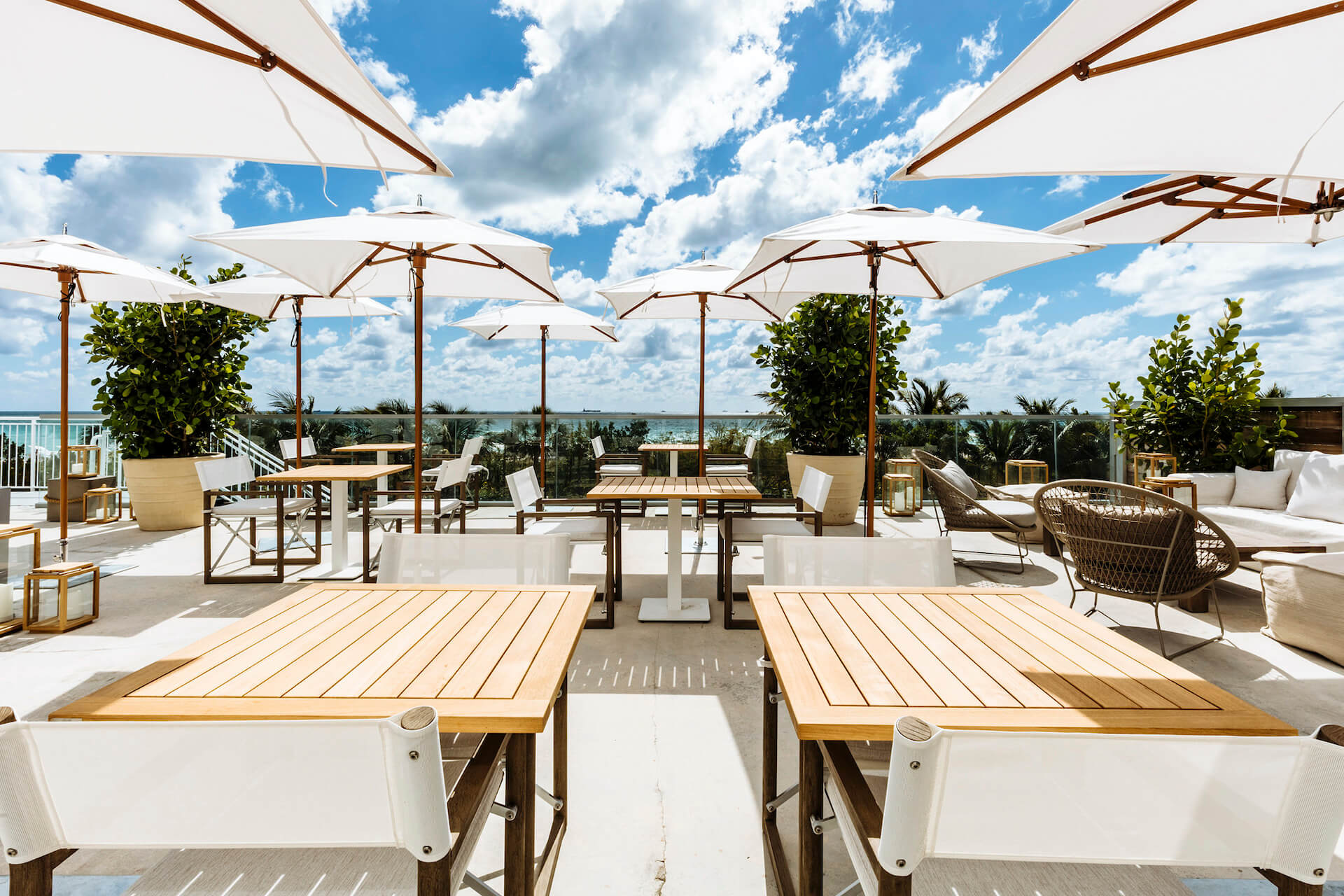 1 Hotel South Beach Terasse mit Tischen und Sonnenschirmen