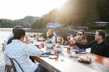 Eine Familie sitzt gemeinsam beim Essen in einer Lodge in British Columbia.
