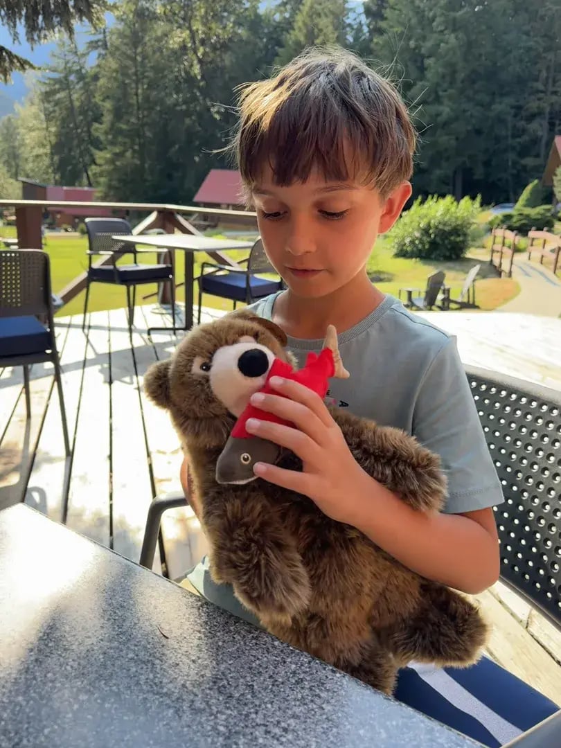 Ein Junge spielt mit einem Teddy.