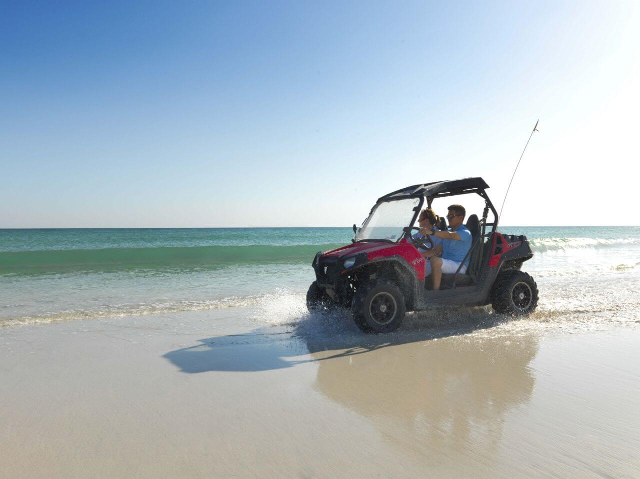 Ein Buggy fährt am Strand entlang.