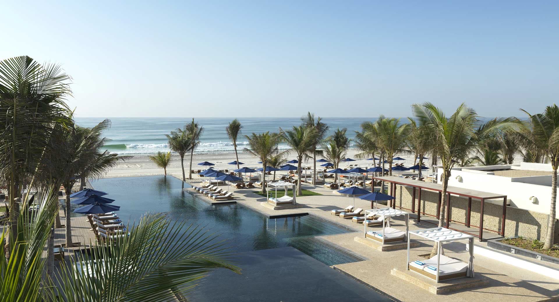 Blick vom Hotel über die Infinity-Poollandschaft bis zum Meer.