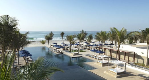 Blick vom Hotel über die Infinity Poollandschaft bis zum Meer.