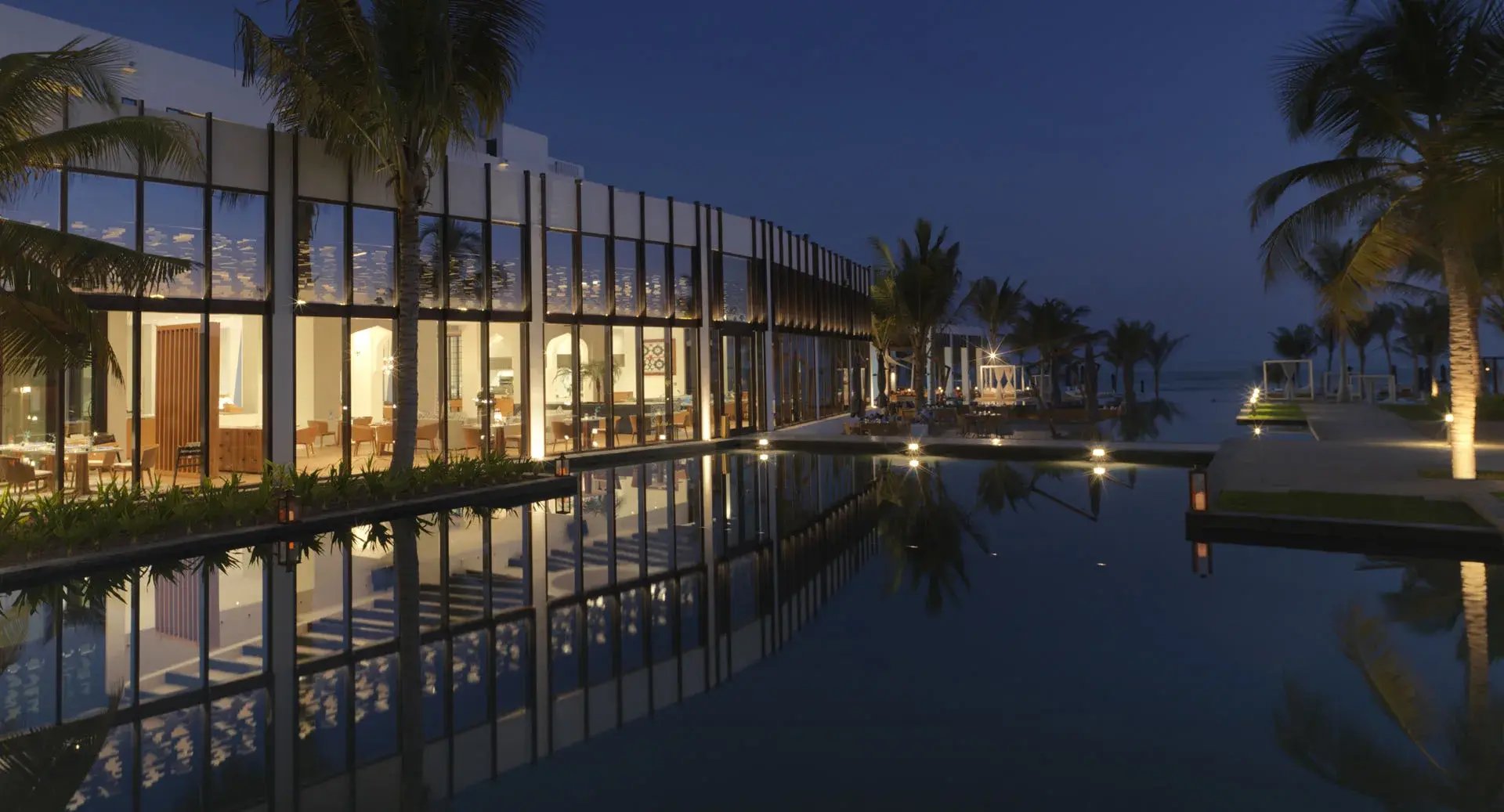 Außenbereich eines Resorts mit Infinity-Pool am Abend.