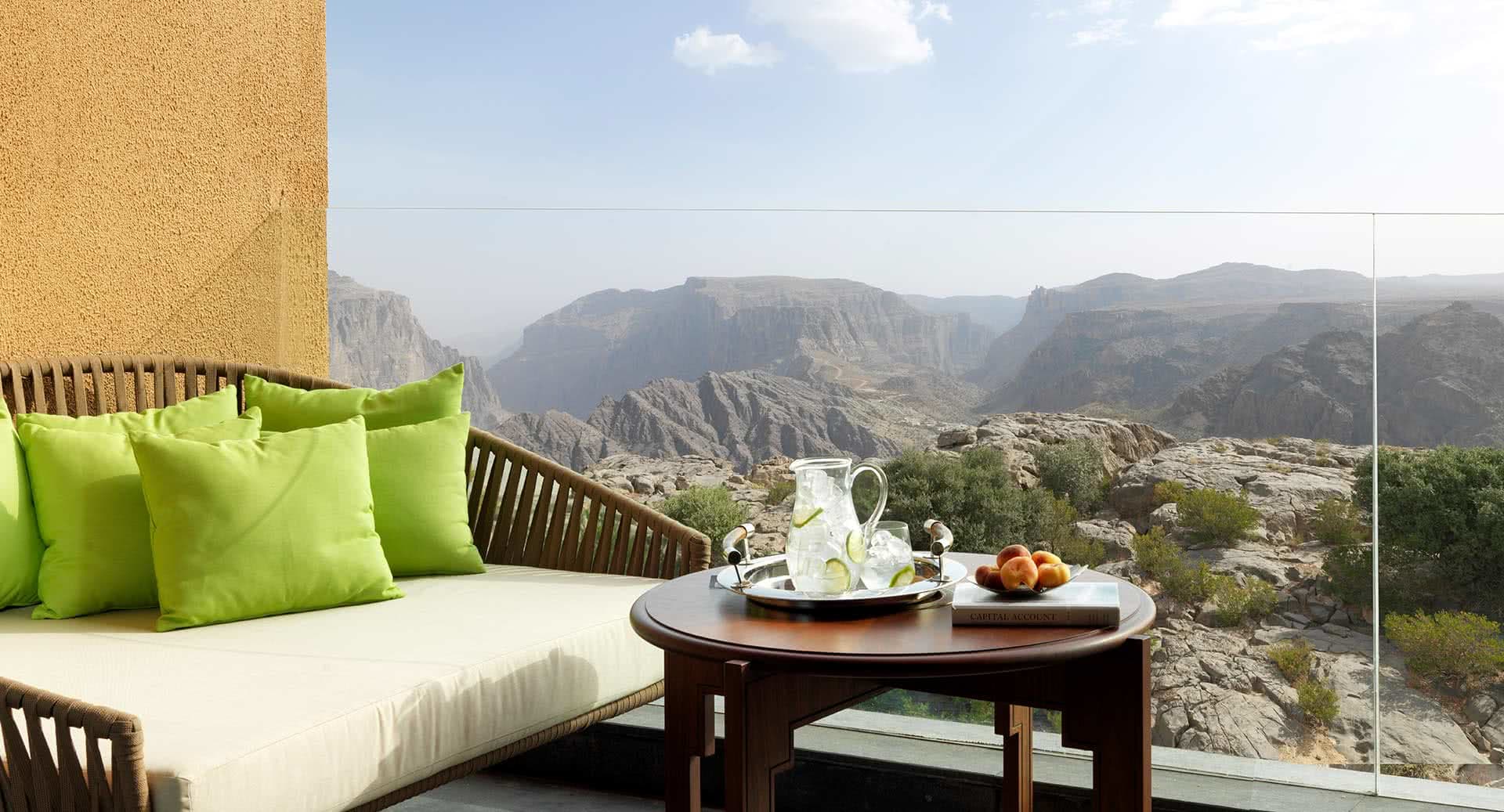 Balkon mit Sofa, Tisch und toller Aussicht auf Bergwelt.