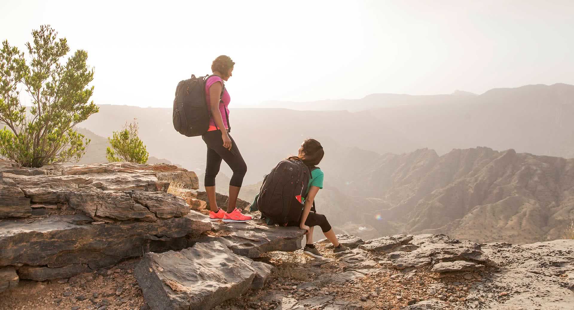 Zwei Frauen wandern durch Gebirge.